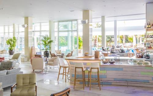 a restaurant with tables and chairs and windows at Amadria Park Beach Hotel Jure in Šibenik
