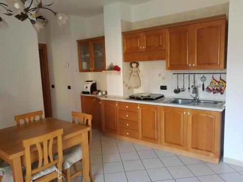 a kitchen with wooden cabinets and a wooden table at A Casetta in Putignano