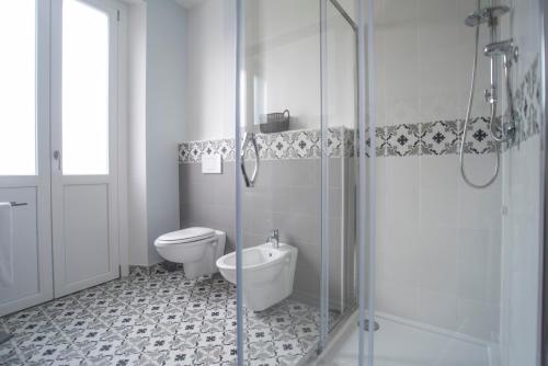 a bathroom with a toilet and a glass shower at Casa Solmes Rooms in Olbia