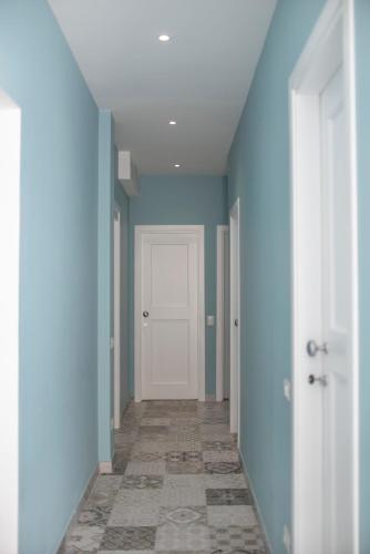 an empty hallway with blue walls and a white door at Casa Solmes Rooms in Olbia