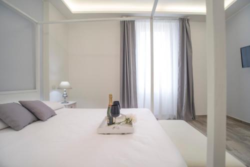 een witte slaapkamer met een wit bed en een raam bij Casa Solmes Rooms in Olbia