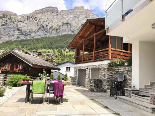 a patio with a table and chairs in front of a house at Apartments Soldanella in Leukerbad