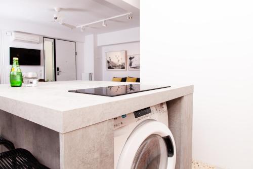 a kitchen and living room with a washing machine at Vouliagmeni Art Micro Loft in Athens