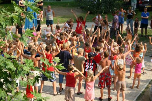 a group of children raising their hands in the air at Campeggio Conca D'Oro in Baveno