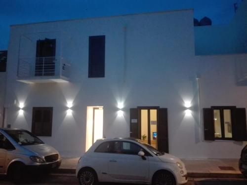 two cars parked in front of a building at night at Patio 101 "Exclusive" in San Vito lo Capo