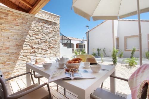 une table blanche avec un bol de fruits dessus dans l'établissement Résidence Odalys Fleur de Sel, à Aigues-Mortes