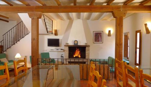 sala de estar con chimenea, mesa y sillas en Casa rural El Pinche, en Espinoso del Rey
