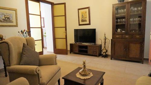 a living room with a couch and a television at Born 23 - House with Pool in the centre of Lluchmayor. free wifi in Llucmajor