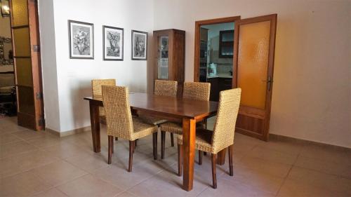a wooden dining room table with wicker chairs at Born 23 - House with Pool in the centre of Lluchmayor. free wifi in Llucmajor