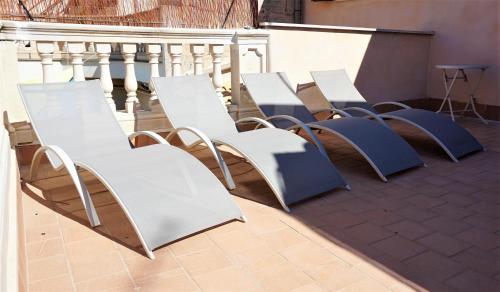 a row of chairs and tables on a balcony at Born 23 - House with Pool in the centre of Lluchmayor. free wifi in Llucmajor