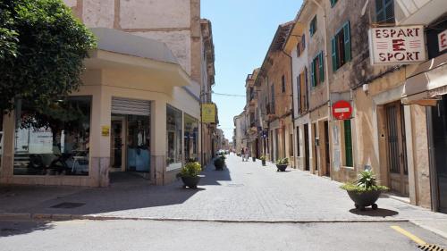 an empty street with potted plants on the sidewalk at Born 23 - House with Pool in the centre of Lluchmayor. free wifi in Llucmajor
