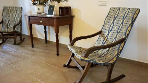 a wooden rocking chair next to a desk with a laptop at Born 23 - House with Pool in the centre of Lluchmayor. free wifi in Llucmajor