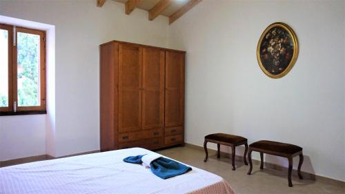 a bedroom with a bed and a cabinet and two chairs at Born 23 - House with Pool in the centre of Lluchmayor. free wifi in Llucmajor