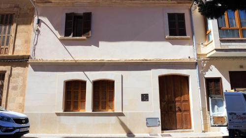 a white building with brown shutters on a street at Born 23 - House with Pool in the centre of Lluchmayor. free wifi in Llucmajor