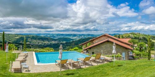uma villa com piscina e cadeiras em Relais Borgo del Gallo em Acqui Terme
