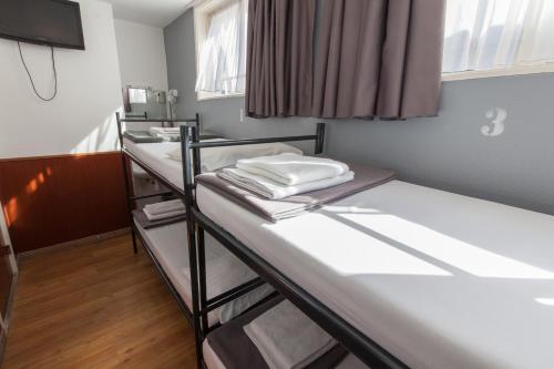 a room with two bunk beds and a television at Travel Hotel Amsterdam in Amsterdam