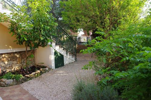 a garden with a staircase leading up to a house at Apartments Sonja Podgora in Podgora