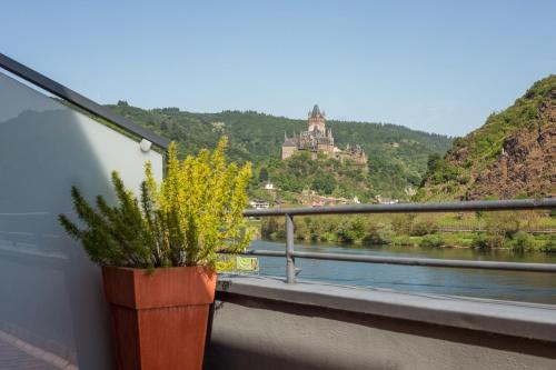 a view from a balcony of a building with a view of a river at Stumbergers Hotel in Cochem