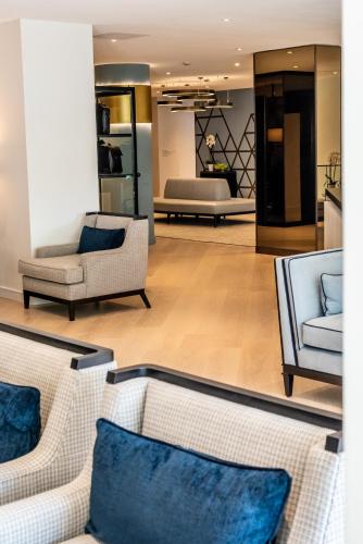 a living room with couches and blue pillows at Columbus Hotel Monte-Carlo, Curio Collection by Hilton in Monte Carlo