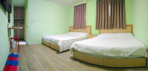 台北的住宿－嘉荣青年旅舍，铺有木地板的医院客房的两张床