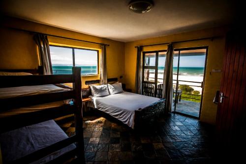 a bedroom with two bunk beds and a view of the ocean at Island Vibe Jeffreys Bay in Jeffreys Bay