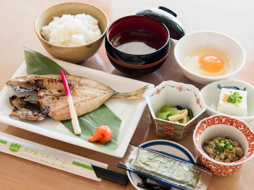 a table with a plate of food with rice and vegetables at Hotel Belleforet in Tsushima