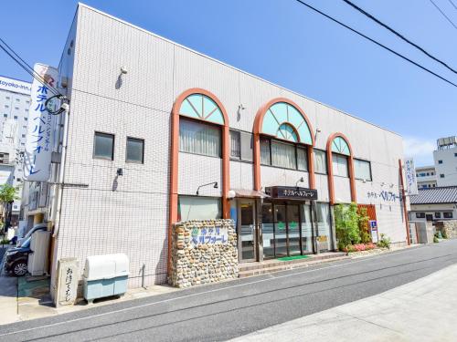 a building on a city street with a street at Hotel Belleforet in Tsushima