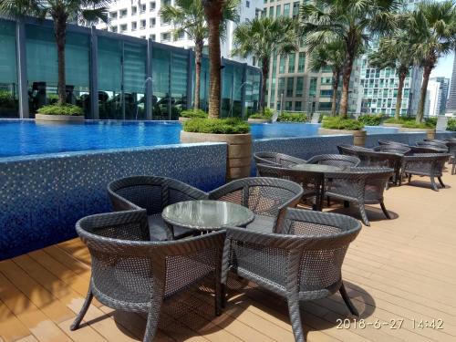 a row of tables and chairs next to a pool at Stella Maison KLCC in Kuala Lumpur