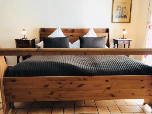 a bedroom with a large wooden bed with pillows at Alter Ackerbuergerhof in Bad Frankenhausen