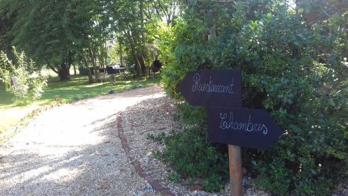 a sign in front of a bush with a path at Les chambres de la Cour in Arsimont