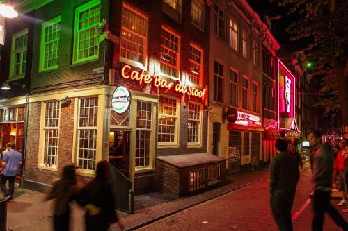 a group of people walking down a street at night at Travel Hotel Amsterdam in Amsterdam