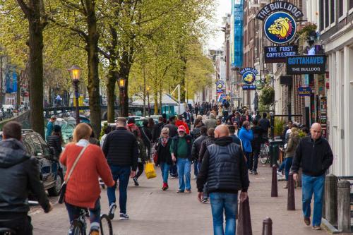 a crowd of people walking down a busy city street at Travel Hotel Amsterdam in Amsterdam