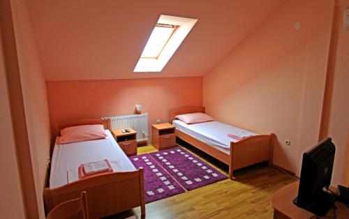 a small room with two beds and a television at Apartments Klanac in Osijek