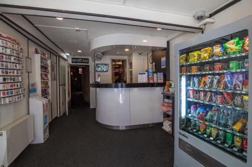a store aisle with a counter and a refrigerator at Travel Hotel Amsterdam in Amsterdam