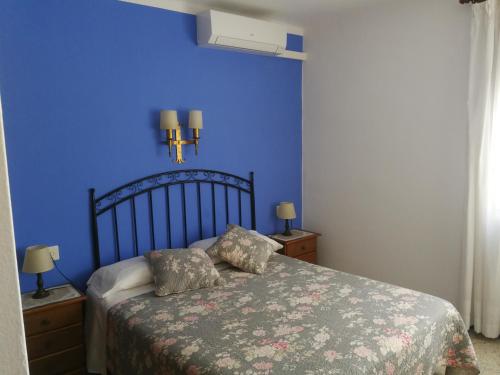um quarto com uma cama com uma parede azul em Pensio Can Fabrellas em Sant Antoni de Calonge