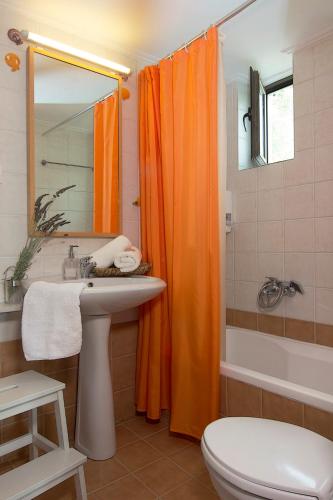 an orange shower curtain in a bathroom with a sink at Kripia Holiday Villas in Kardamyli
