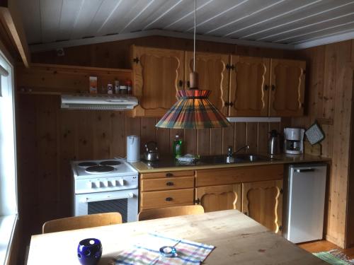 a kitchen with a stove and a table with chairs at Putten Seter in Høvringen