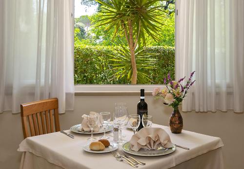 un tavolo con piatti e una bottiglia di vino di Hotel Mediterraneo a Marina di Pietrasanta