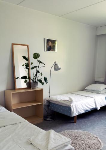 a room with two beds and a mirror and a lamp at Summer Apartments Mänttä in Mänttä