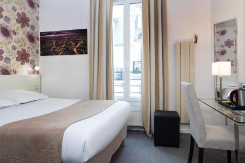 パリにあるホテル ソフトのベッド、デスク、窓が備わるホテルルームです。