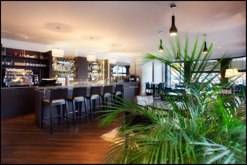 eine Bar mit schwarzen Stühlen und einer Theke in der Unterkunft Hotel Le Berry in Saint-Nazaire
