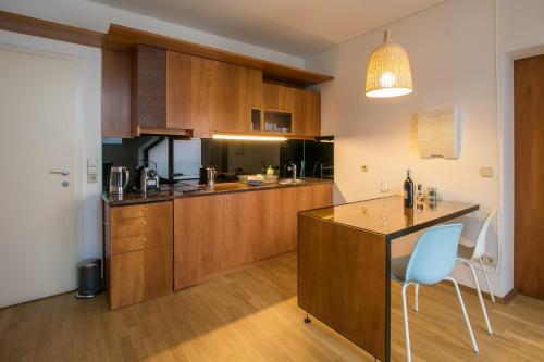 a kitchen with wooden cabinets and a blue chair at Flataid Apartment Schießstattgasse in Graz