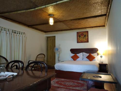 a bedroom with a bed and a table and chairs at Rheinberg Town Haus in Munnar