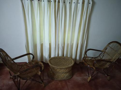 two chairs and a basket in front of a radiator at Rheinberg Town Haus in Munnar