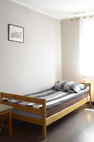 a bedroom with a wooden bed in a room at Pokoje Gościnne in Lębork