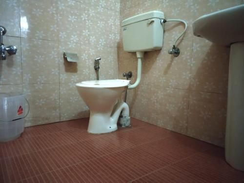 bagno con servizi igienici e box doccia. di Rheinberg Town Haus a Munnar
