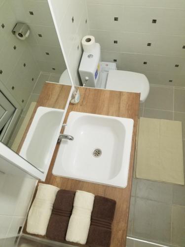 a bathroom with a white sink and a mirror at Sky Apartments in Strumica