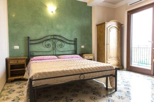 a bedroom with a bed and a green wall at Rianna Rooms & Breakfast in Scala