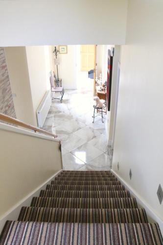 a staircase leading up to a living room at Emy Lakehouse - near Castle Leslie, Glaslough in Monaghan