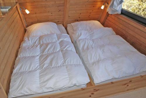a small bed in a room with white sheets at Zeltdachhaus mit WLAN in Strandnaehe in Damp
